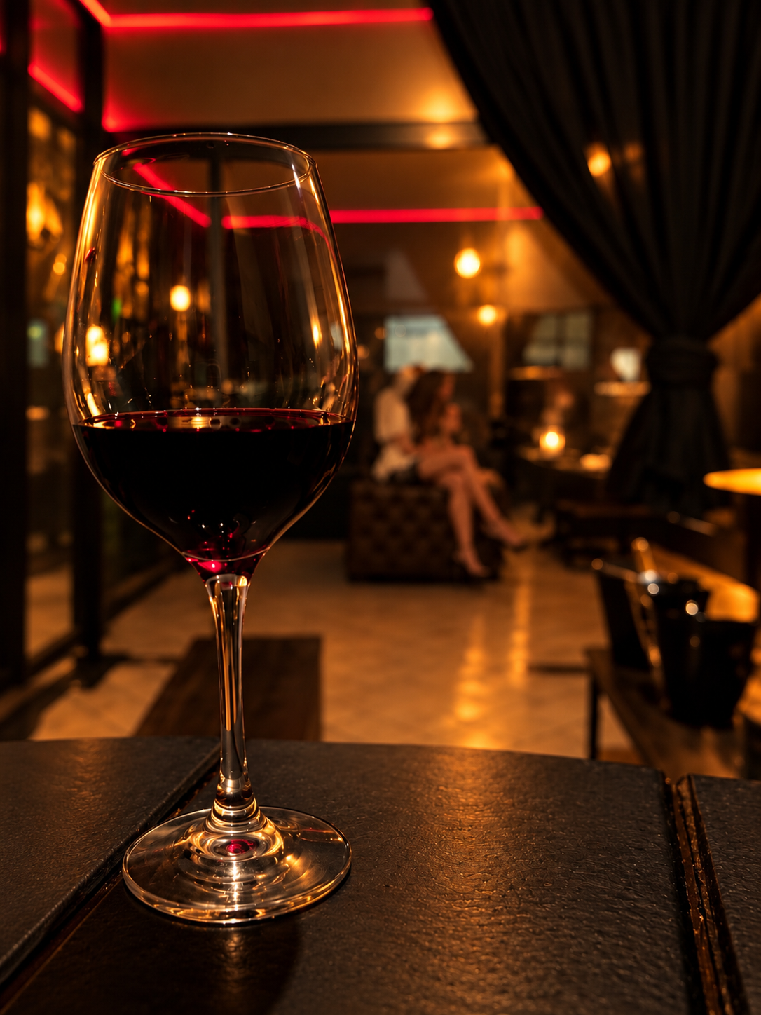 Taça de vinho no ambiente sofisticado do bar da Mansão 147 Premium